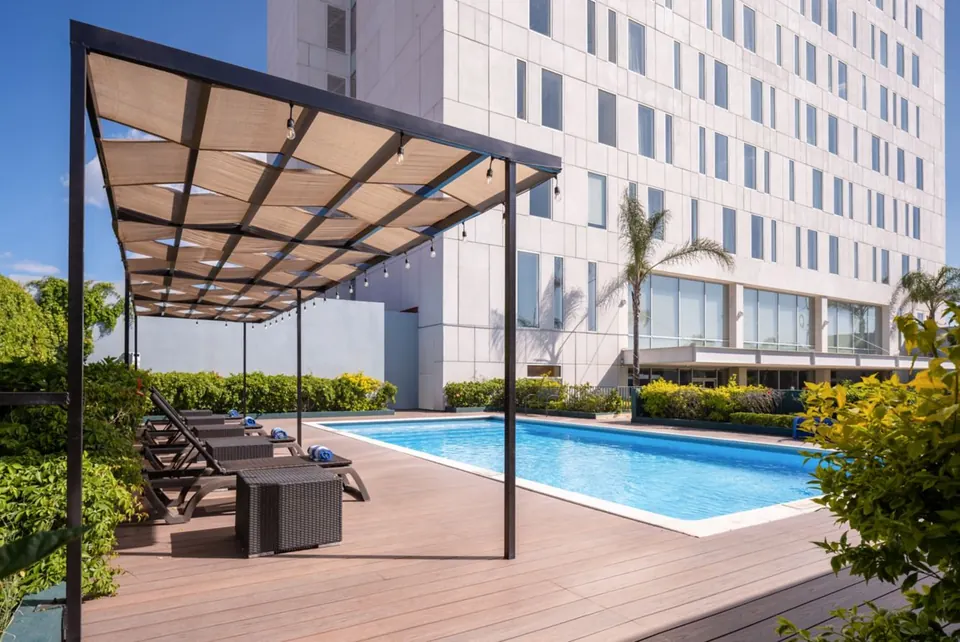Terraza con piscina y la torre del hotel
